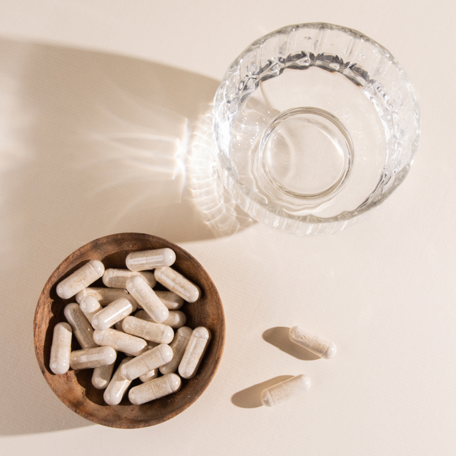 A picture with a bowl filled with Keratin with Biotin Hair Boosters Capsules by Crushed Tonic next to a glass bowl